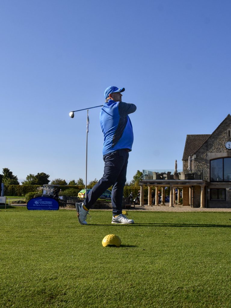 A man swings a golf club