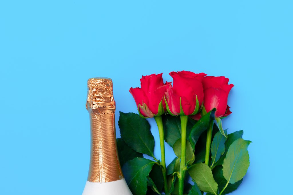 Champagne and roses on a blue background 