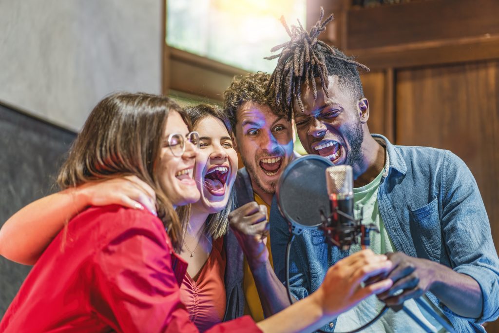 A group of people sing into a microphone