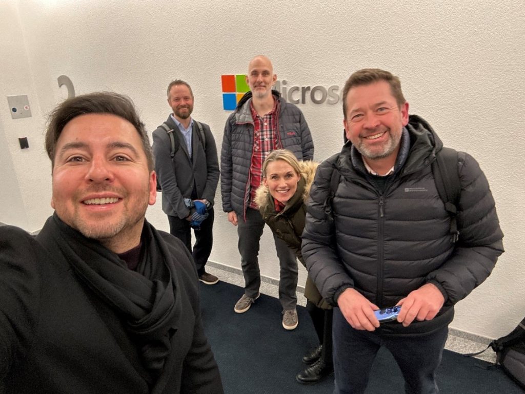 Five people taking a smiling selfie