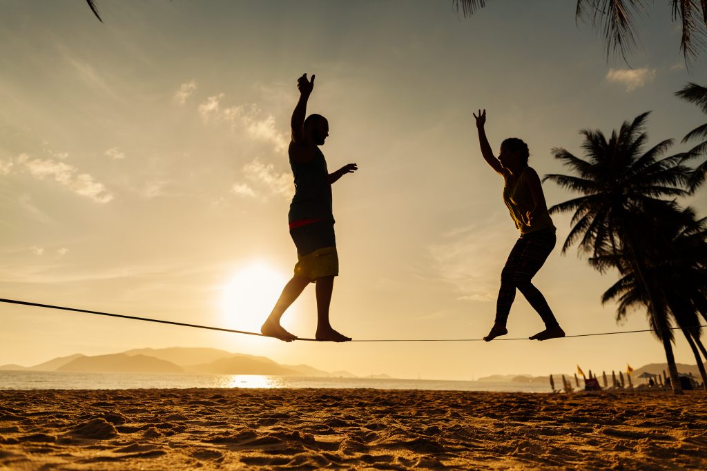 Two people balance on a slack line