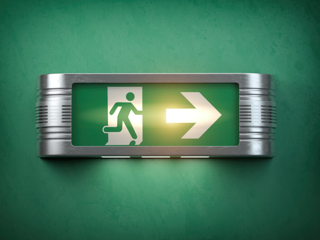A green, glowing, exit sign