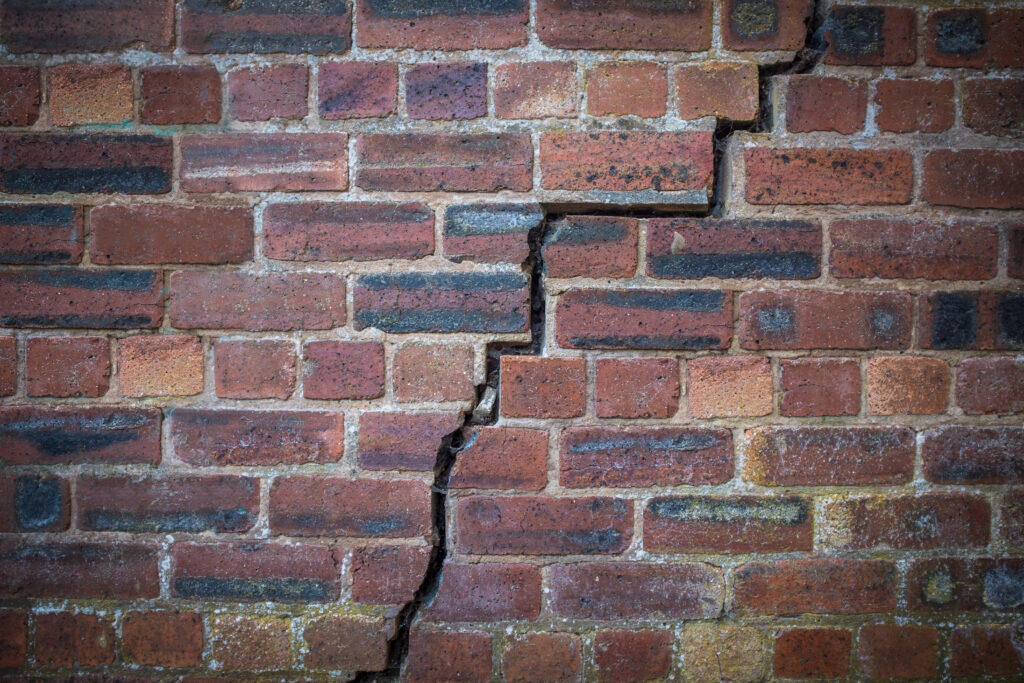 A cracked red-brick wall