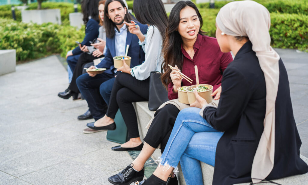 People chat outside while eating lunch