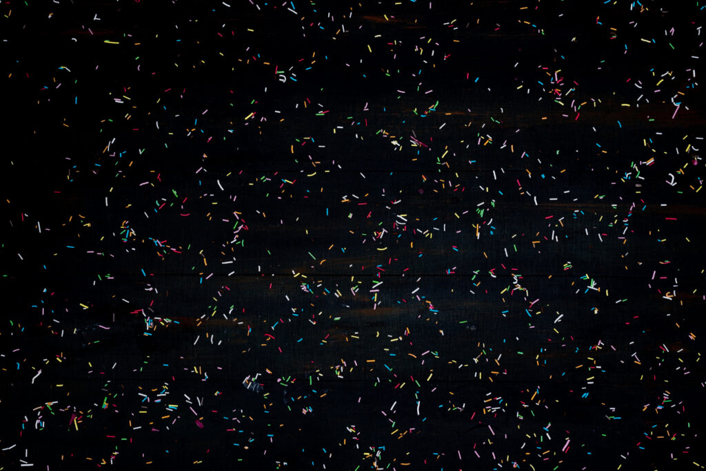 Tiny coloured strand are spread over a dark background