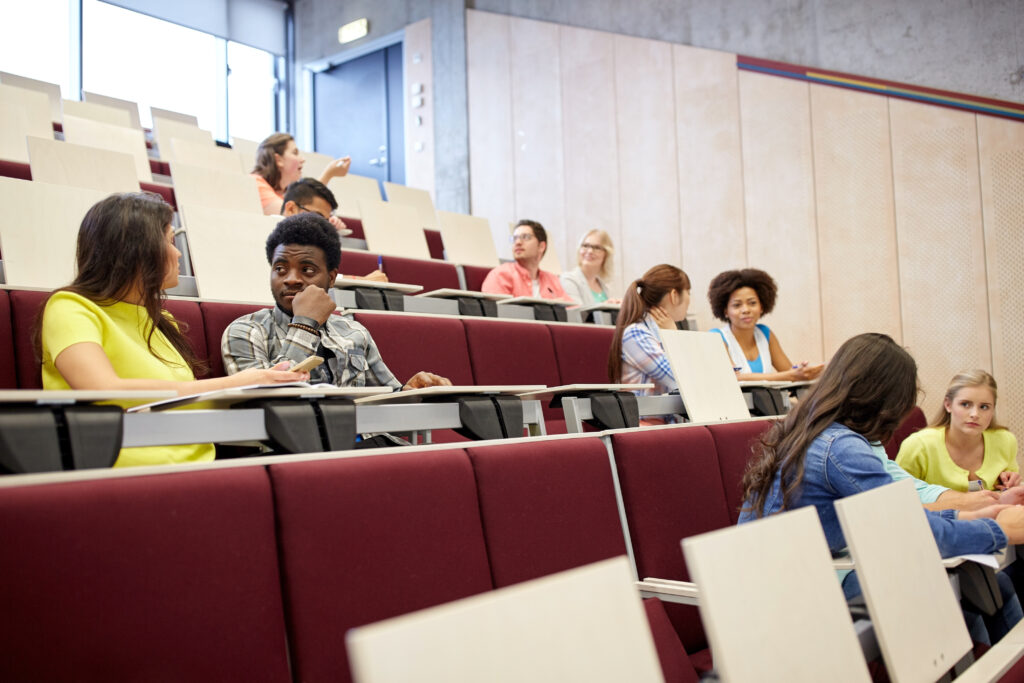A lecture hall with a few students seated