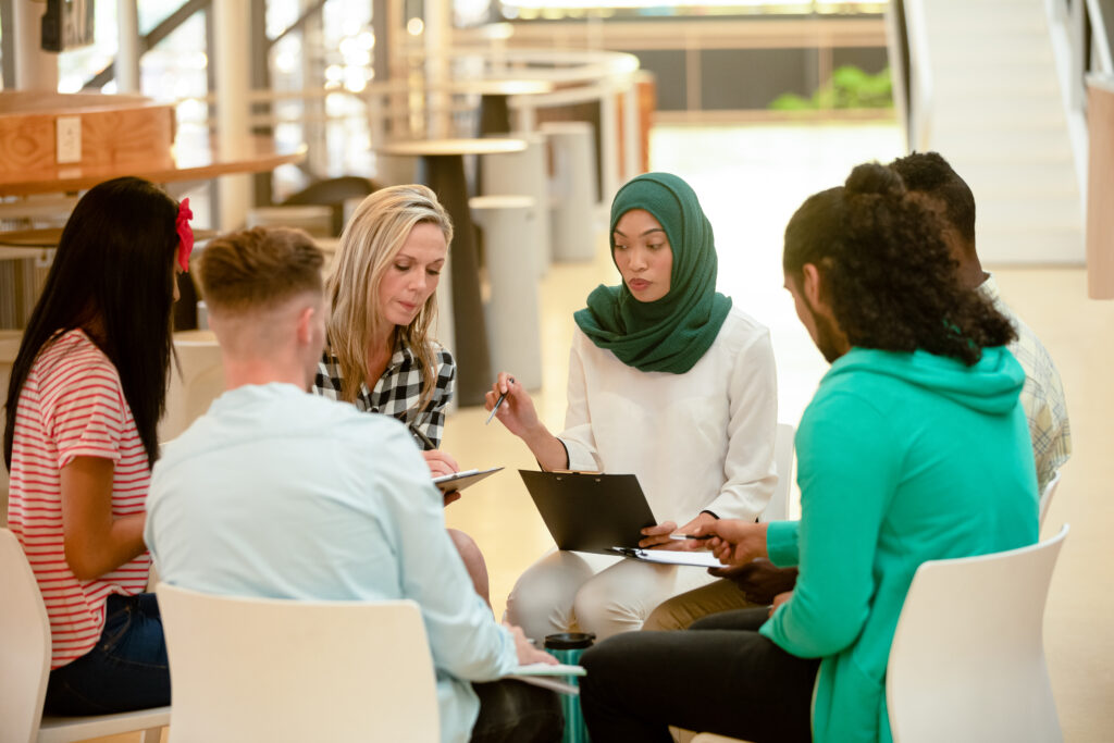 University students sitting in a circle, discussing their coursework