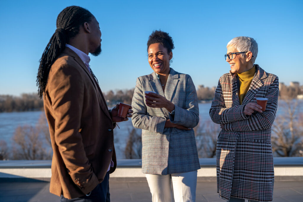 Three people chat outside