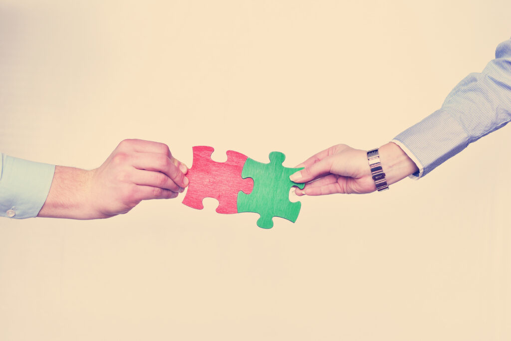 Two arms connecting with puzzle pieces