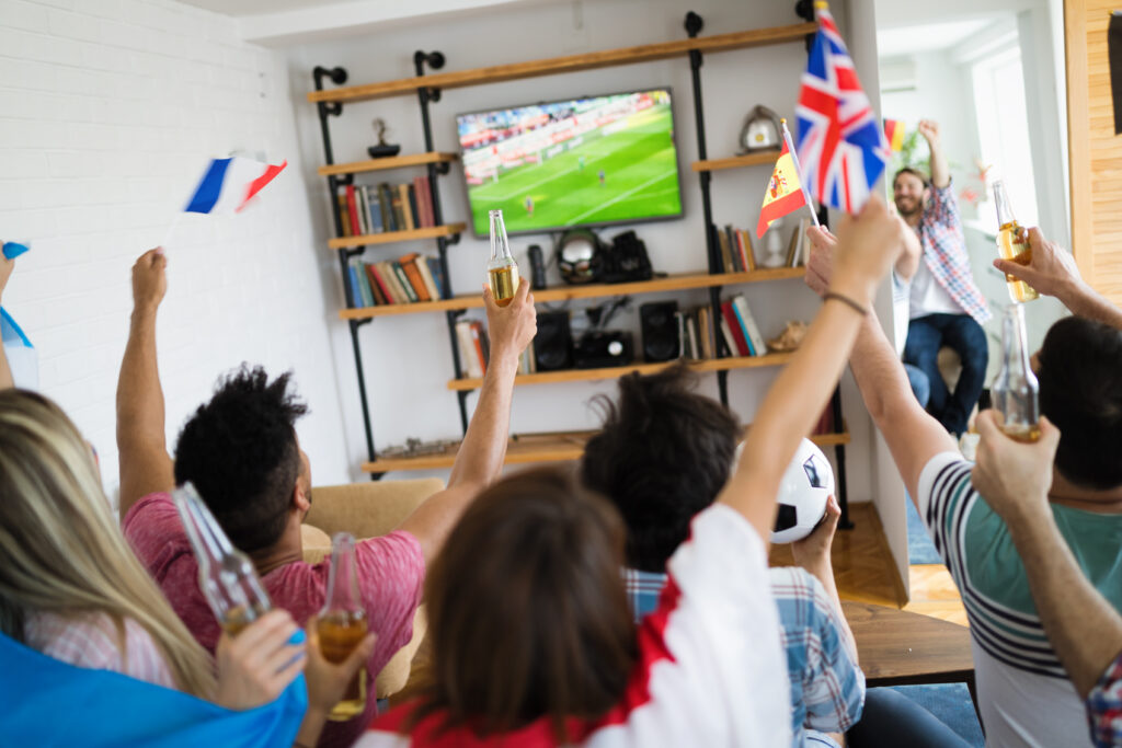 Group of friends watching football on TV