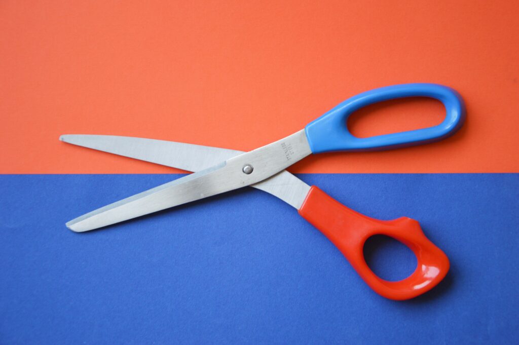 A pair of scissors on red and blue paper